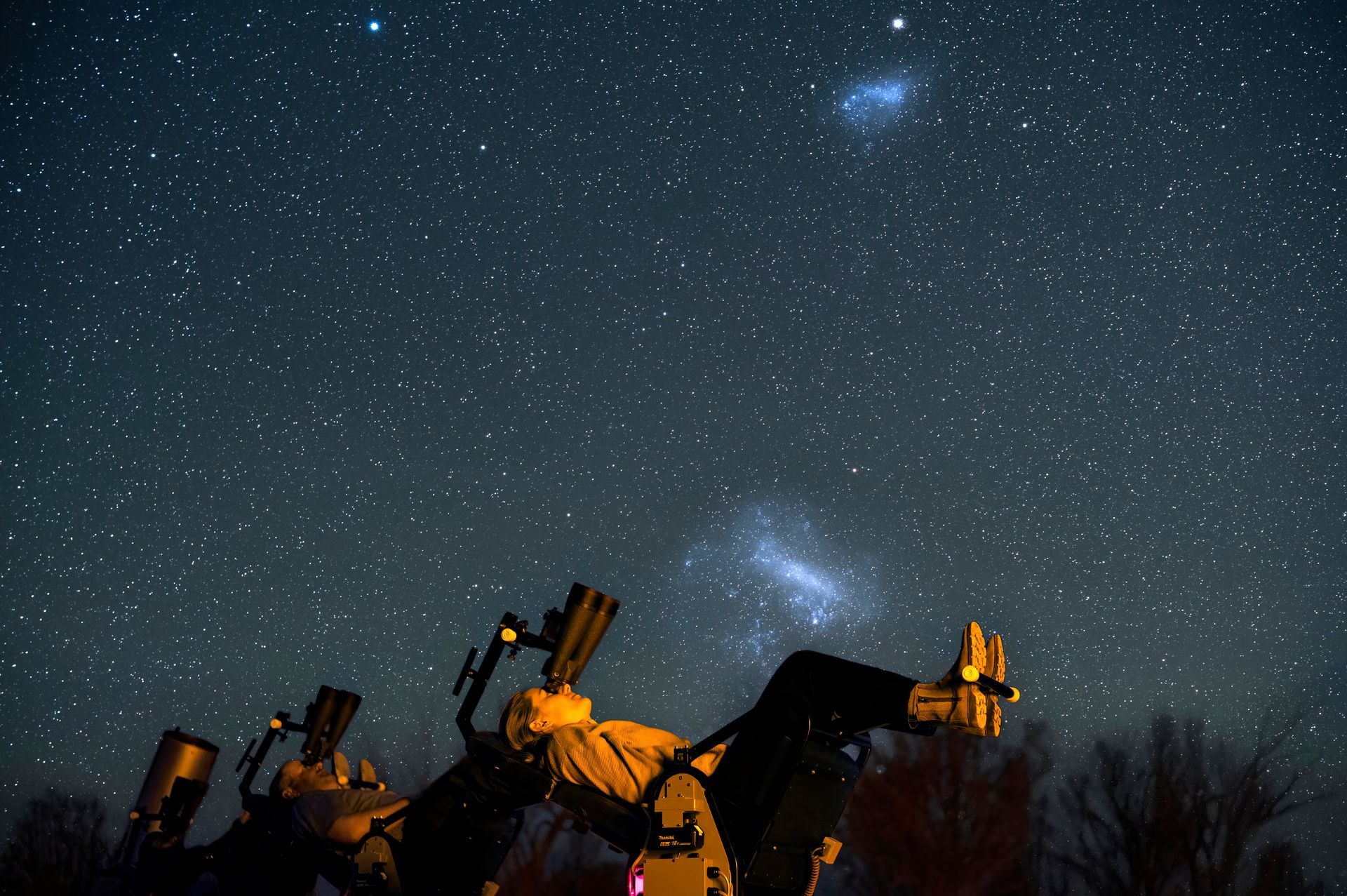 Guests using astronomy binoculars from reclining robotic stargazing chairs at Arkaroola